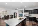 Spacious kitchen featuring a center island, dark cabinets, and open layout to the dining area at 5345 W Leodra Ln, Laveen, AZ 85339