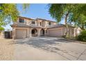 Inviting two-story home showcasing a three-car garage and a charming front entrance with arched accents at 5422 W Bryce Ln, Glendale, AZ 85301