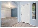 Welcoming foyer with a white front door and a view into a carpeted living area with blue accent wall at 5422 W Bryce Ln, Glendale, AZ 85301