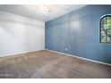 An empty living room features a blue accent wall and a window with natural light at 5422 W Bryce Ln, Glendale, AZ 85301