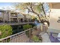 Balcony view overlooking a serene waterfront with a fountain and lush landscaping at 705 W Queen Creek Rd # 1157, Chandler, AZ 85248