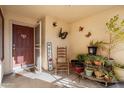 Cozy front porch with decorative butterflies, potted plants, and a rocking chair, creating a welcoming outdoor space at 8736 W Kathleen Rd, Peoria, AZ 85382