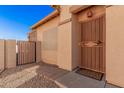 Close-up of front door with security screen and tiled walkway leading to a gated side yard at 10352 E Second Water Trl, Gold Canyon, AZ 85118