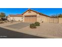 Single-story home with desert landscaping, a two-car garage and a decorative wrought iron side gate at 10352 E Second Water Trl, Gold Canyon, AZ 85118