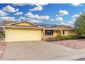 Inviting single-story home featuring a yellow facade, 2-car garage, and solar panels at 10414 W Ponderosa Cir, Sun City, AZ 85373