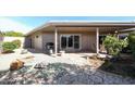 Cozy backyard featuring a covered patio, mature trees, and rock garden at 10461 W Loma Blanca Dr, Sun City, AZ 85351