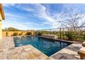 Relaxing pool area featuring cool blue water, a tranquil fountain, and a meticulously landscaped yard at 12413 W Calle De Baca --, Peoria, AZ 85383