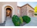 Beautiful front entry with an arched entryway, natural light, and lush landscaping at 12835 W Black Hill Rd, Peoria, AZ 85383