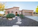 Attractive single-story home featuring low-maintenance desert landscaping, stone accents, and an arched entryway at 12835 W Black Hill Rd, Peoria, AZ 85383