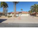 Charming single-story home featuring desert landscaping, mature palm trees, and a two-car garage at 13232 W Ballad Dr, Sun City West, AZ 85375