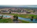 Picturesque aerial view featuring a tranquil waterway surrounded by verdant green spaces in a residential community at 14264 S Baniff Ln, Arizona City, AZ 85123