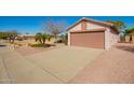 Exterior shot of a single-story home with a two-car garage and desert landscaping at 14946 W Caribbean Ln, Surprise, AZ 85379