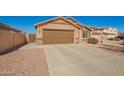 Single-level home with a desert rock yard, wide driveway, and a two-car garage at 16150 W Hope Dr, Surprise, AZ 85379