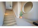 Carpeted staircase featuring a modern mirror and decorative cactus, creating an inviting and stylish transition between floors at 16420 N Thompson Peak Pkwy # 2120, Scottsdale, AZ 85260