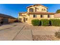 Charming two-story home with a long driveway and well-maintained landscaping featuring flowering bushes at 16528 W Pierce St, Goodyear, AZ 85338