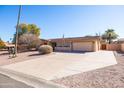 Spacious driveway leads to an attached two-car garage and a cozy home with desert landscaping at 17217 E Calaveras Ave, Fountain Hills, AZ 85268