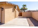 Private side yard features a wooden gate, concrete patio, and mature landscaping at 17217 E Calaveras Ave, Fountain Hills, AZ 85268