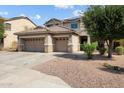 Inviting two-story home with a spacious three-car garage and well-maintained desert landscaping at 18118 W Golden Ln, Waddell, AZ 85355