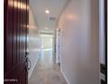 Inviting hallway with tile flooring, neutral walls, and recessed lighting leading to an open living space at 23229 W Florence Ave, Buckeye, AZ 85326