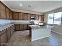 Modern kitchen with granite countertops, stainless steel appliances, and a center island with a sink at 23229 W Florence Ave, Buckeye, AZ 85326