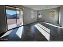 Bright living room with tile flooring, large sliding glass doors, and multiple windows offering backyard views at 23229 W Florence Ave, Buckeye, AZ 85326