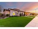 A well maintained stone home with a green lawn and paved walkway leading to the front entrance at 2799 E Waterman St, Gilbert, AZ 85297