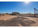 Expansive gravel driveway leads to a cozy home, set against a backdrop of desert landscape at 29409 N 220Th Ave, Wittmann, AZ 85361