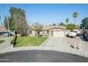 Charming single-story home on a corner lot featuring a lush green lawn and an extended driveway with RV parking at 3119 S Stewart Cir, Mesa, AZ 85202