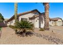 Charming single-story home featuring a two-car garage, desert landscaping, and a clear blue sky at 3232 E Hononegh Dr, Phoenix, AZ 85050