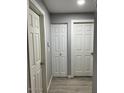 Clean hallway featuring light grey walls, modern flooring, and multiple white doors at 3645 N 69Th Ave # 67, Phoenix, AZ 85033