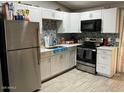 Modern kitchen boasts stainless steel appliances, sleek countertops, tiled backsplash, and ample cabinet space at 3645 N 69Th Ave # 67, Phoenix, AZ 85033