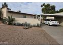 Single-story home with mature desert landscaping and a covered parking area at 3706 S Dennis Dr, Tempe, AZ 85282