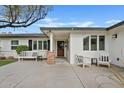 Inviting front porch featuring a white bench, chairs and a modern concrete walkway at 3922 E Elm St, Phoenix, AZ 85018