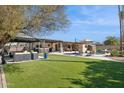 Expansive backyard oasis with a pool, hot tub, covered patio, and lush artificial turf at 5401 E Corrine Dr, Scottsdale, AZ 85254