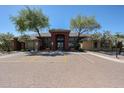 Clubhouse with beautiful trees, flowers, landscaping, and visible parking at 5401 E Van Buren St # 1068, Phoenix, AZ 85008