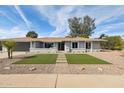 Inviting single-story home featuring a manicured lawn and desert landscaping for low maintenance at 5412 E Tierra Buena Ln, Scottsdale, AZ 85254