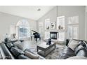 Spacious living room featuring a fireplace, wood floors, and ample natural light at 7318 W Paso Trl, Peoria, AZ 85383