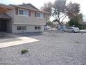 An angle of the front yard with desert rock landscaping, some foliage, and shade trees at 7539 N 50Th Ave, Glendale, AZ 85301