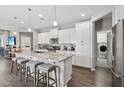 Spacious kitchen features a granite island, modern appliances, white cabinetry, and sleek dark hardwood floors at 7924 S 24Th Pl, Phoenix, AZ 85042