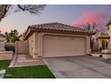 Beige single-story home with a garage, concrete driveway, desert landscaping and well-maintained lawn at 80 S Maple Ct, Chandler, AZ 85226