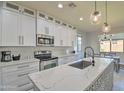 Modern kitchen boasts sleek white cabinetry, stainless steel appliances, and a beautifully designed backsplash at 8966 W State Ave, Glendale, AZ 85305