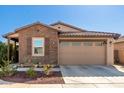 Inviting single-story home featuring a two-car garage, brick accents, and tidy landscaping at 9341 W Willow Bend Ln, Phoenix, AZ 85037