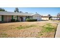 View of the cozy single-story home with an attached garage and well kept lawn at 10105 W Bolivar Dr, Sun City, AZ 85351