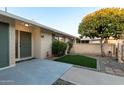 Inviting front entrance with low maintenance synthetic grass, brick wall and lush tree at 10808 W Kelso Dr, Sun City, AZ 85351