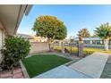 Charming front yard with lush tree, low maintenance synthetic grass and well-maintained landscaping at 10808 W Kelso Dr, Sun City, AZ 85351