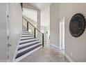 Modern entryway with sleek staircase, gray tile floors, and elegant wall decor at 11537 W Laurelwood Ln, Avondale, AZ 85392
