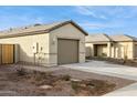 A single story home showcasing the two-car garage and desert landscaping at 12089 E Sunflower Ln, Florence, AZ 85132