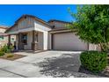 View of a single-story home's driveway and garage, complemented by mature trees and lush greenery at 23027 E Rosa Rd, Queen Creek, AZ 85142