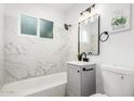 Stylish bathroom with marble wall tiles, modern vanity, and tub, offering a spa-like experience at 2904 W Coolidge St, Phoenix, AZ 85017