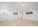 Bright and spacious living room with modern light fixture and new light floors at 2904 W Coolidge St, Phoenix, AZ 85017